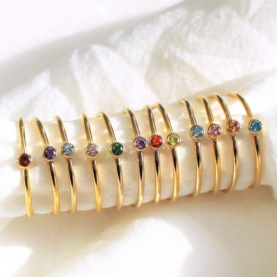 Gold rings with bezel-set birthstones manufactured by Jewels by Nimit