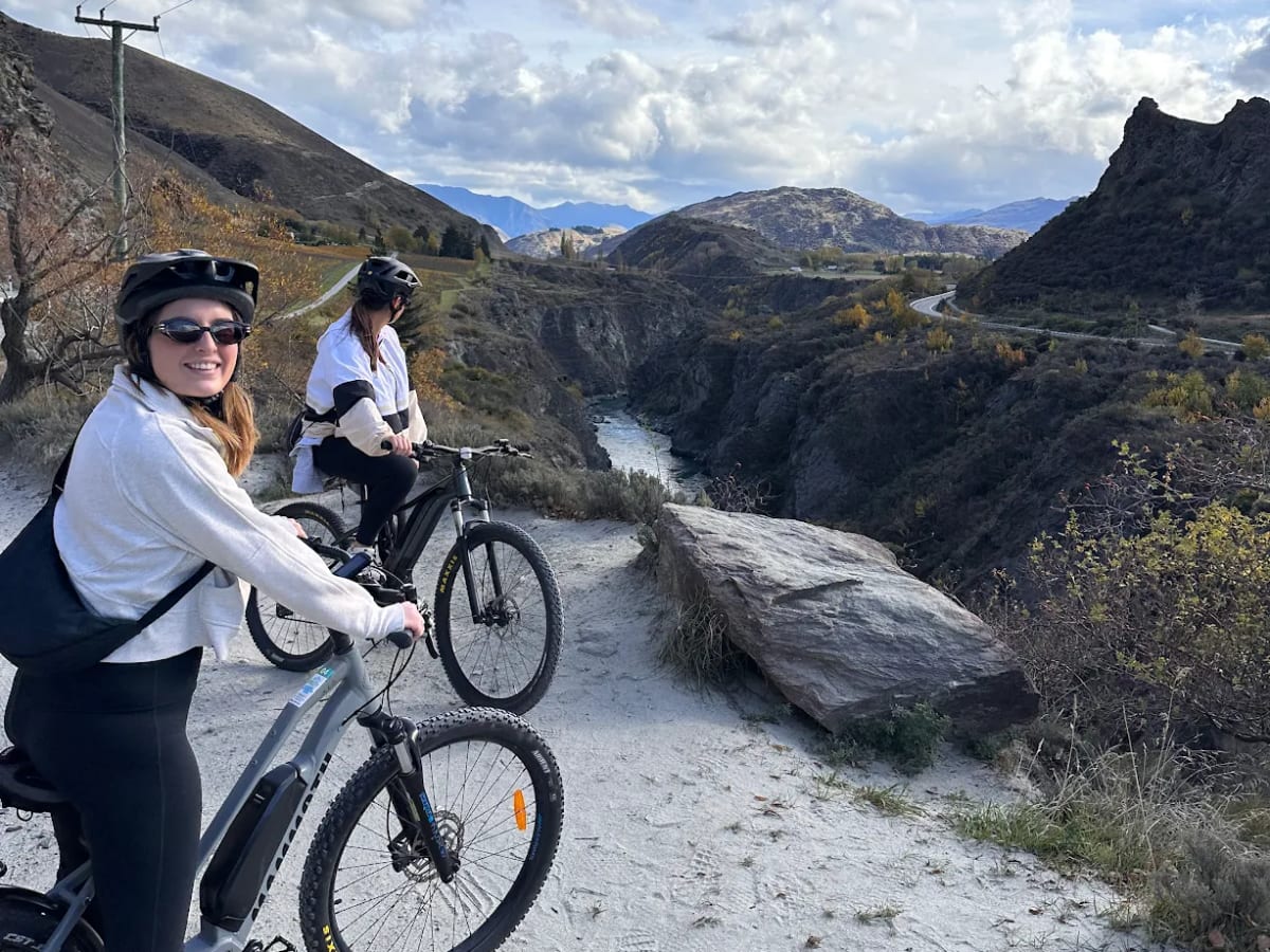 Two friends on their e-bikes at a viewpoint over the Kawarau gorge