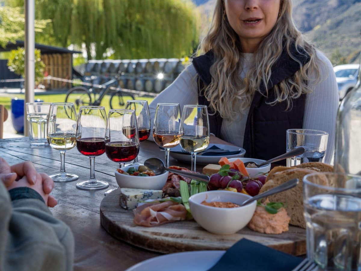 Wine flight and charcuterie board on a cellar door terrace overlooking the vines