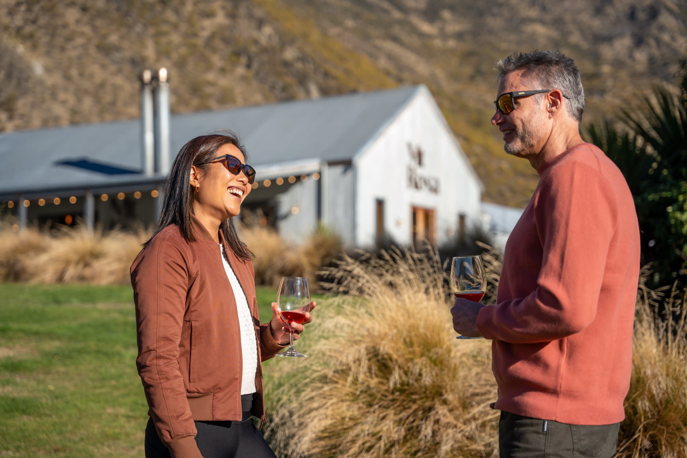 Late afternoon glass of pinot at a Gibbston Valley cellar door, e-bikes parked beside the lawn