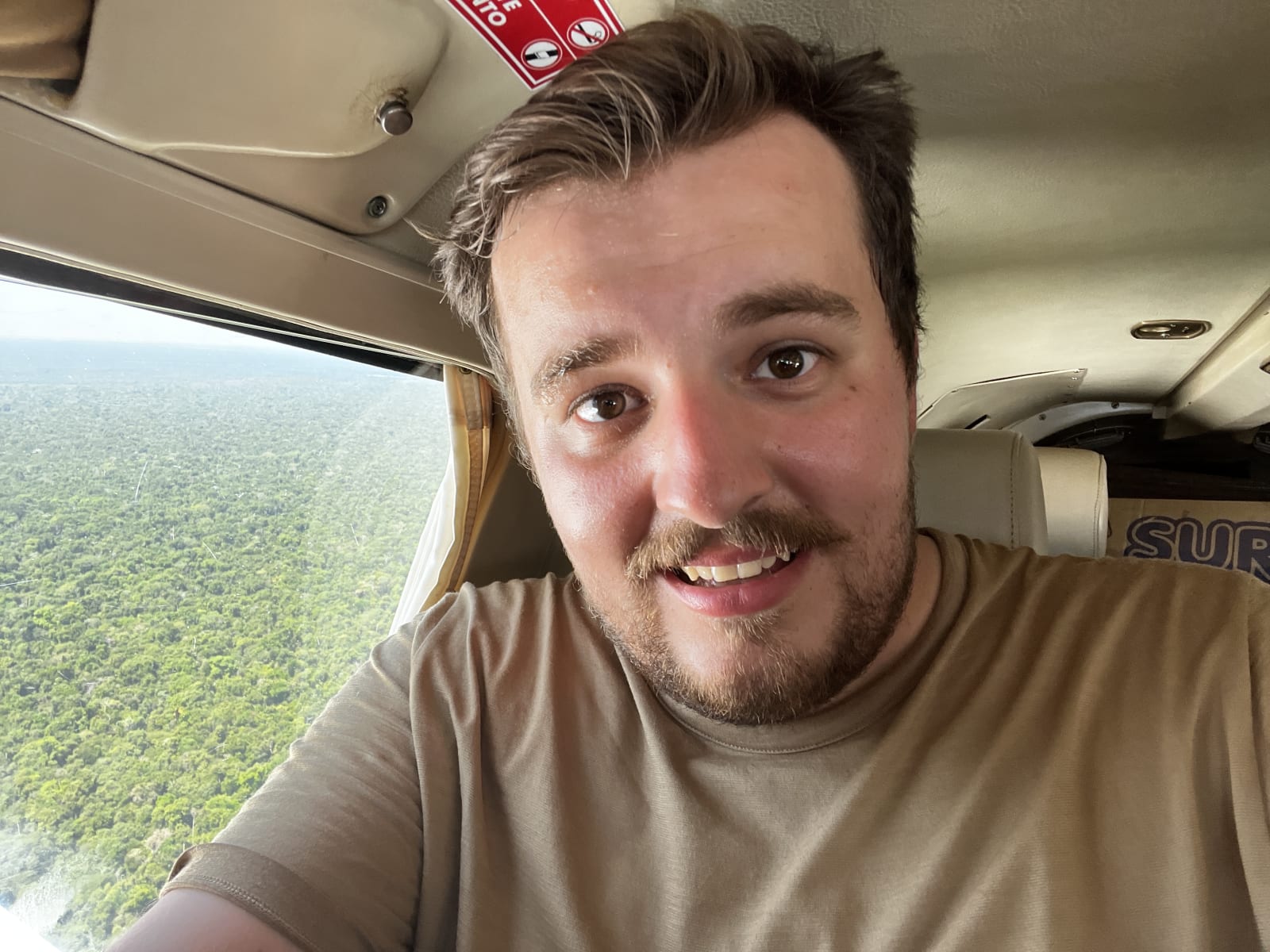 View from inside a small plane flying low over the Amazon rainforest