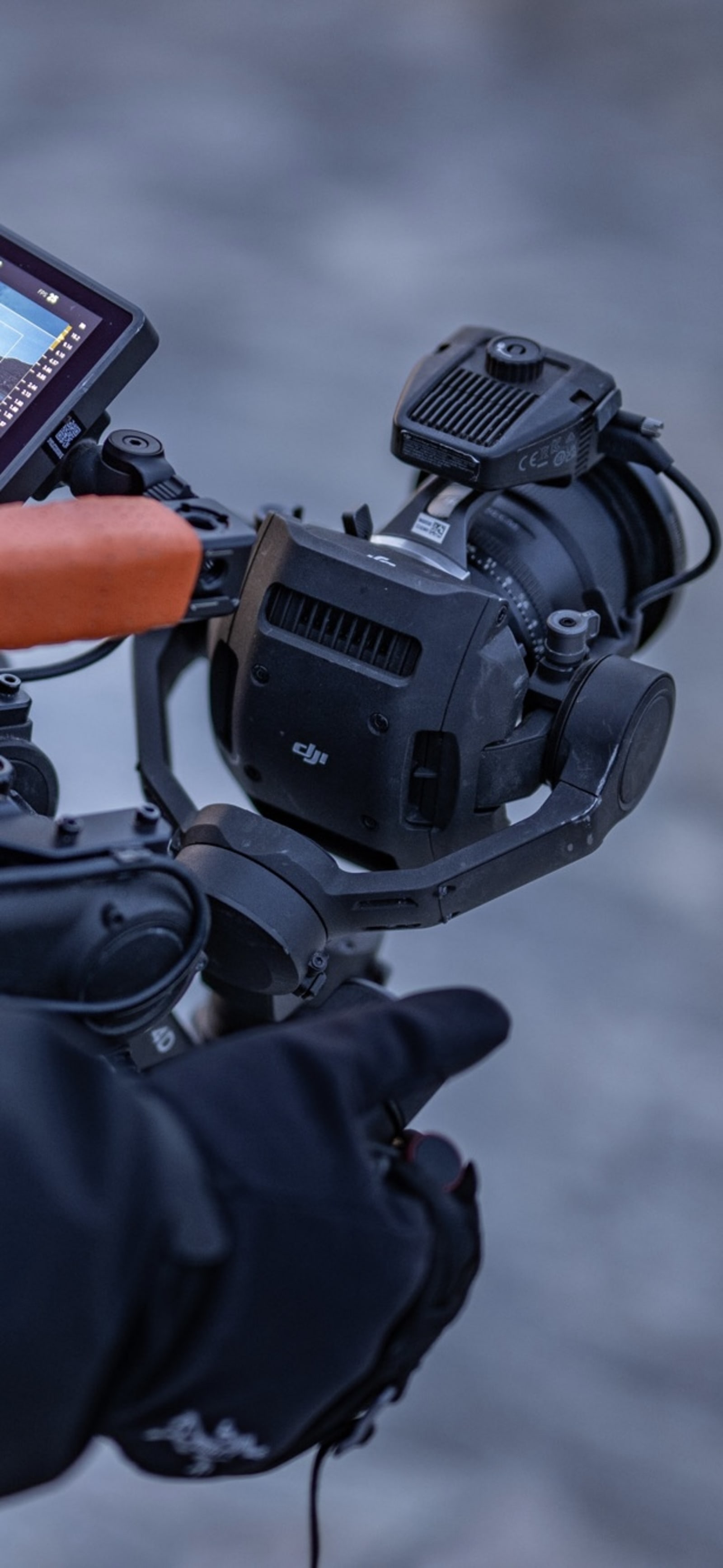 DJI Ronin 4D gimbal, scratched and worn, held in a gloved hand in Greenland