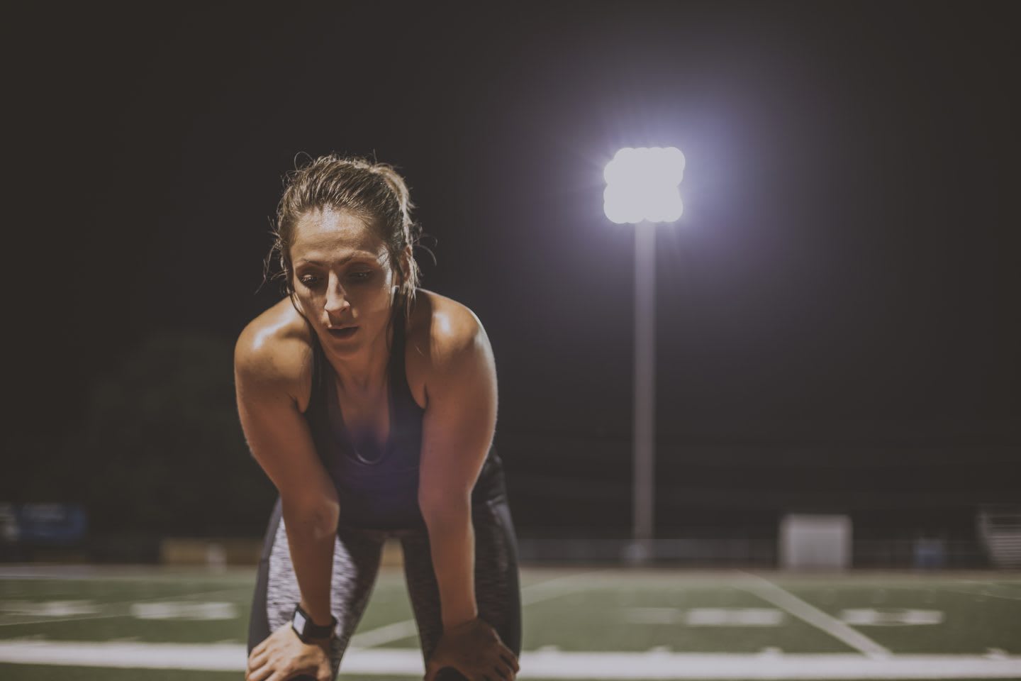 Caucasian female athlete resting on sports field