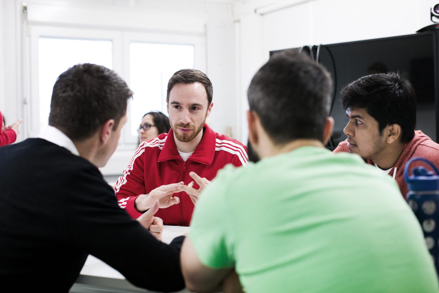 A group of colleagues gathered around a table talking.