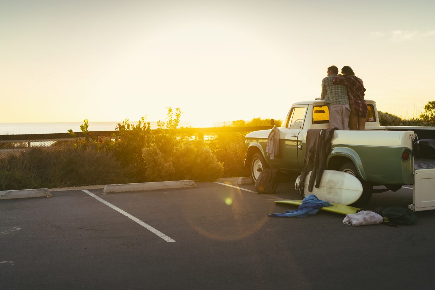 A van in the sunset with a couple on the deck relaxing on top of it_beach_chilling moments_happy days