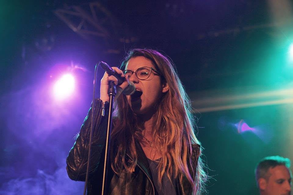 Lina Benabdesslem stands on stage signing. concert, singing, passion, singer, spotlight, stage.