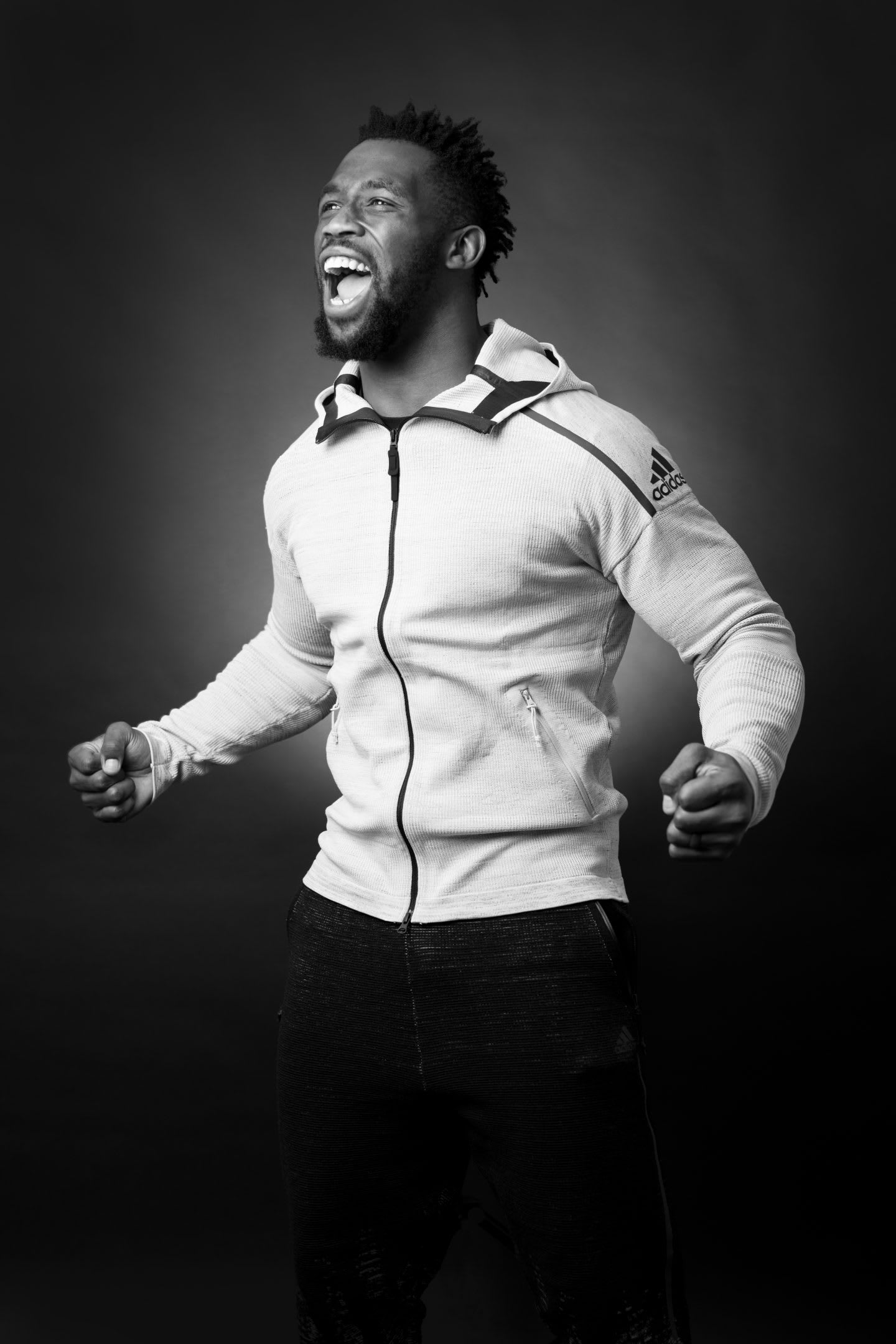 Siya Kolisi stands tall roaring in happiness clenching his fists. Athlete, leadership, success, rugby.