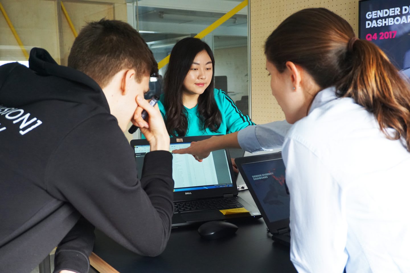 A group of working interns stand by their desks working on their laptops. workplace, motivation, colleagues, concentration, teamwork.