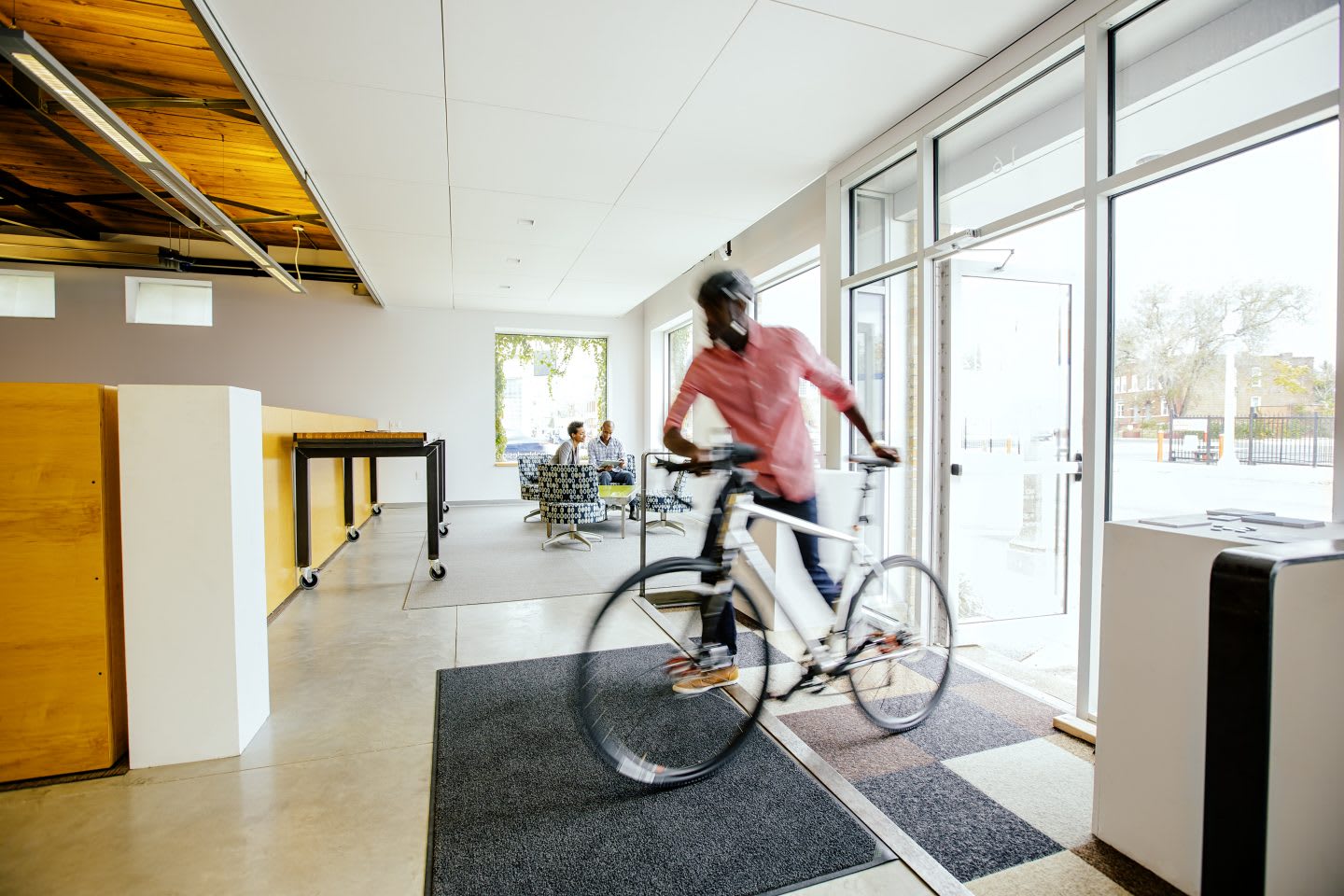 Blurred view of businessman pushing bicycle into office. office, workplace, rushing, bicycle