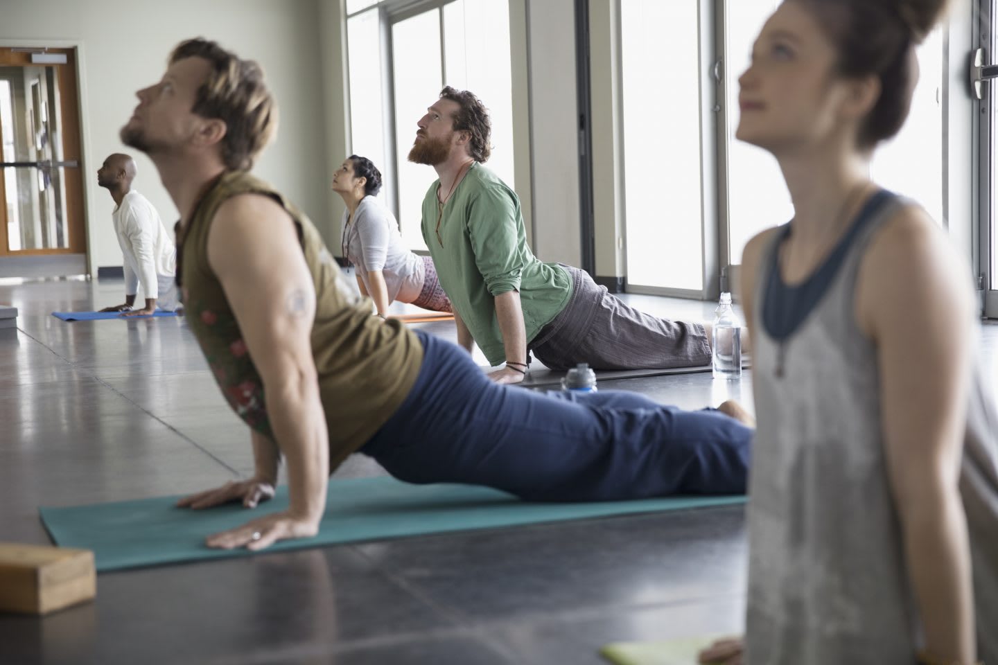 Men and women practicing yoga upward facing dog pose in yoga class studio. yoga, mindfulness, relax, activity