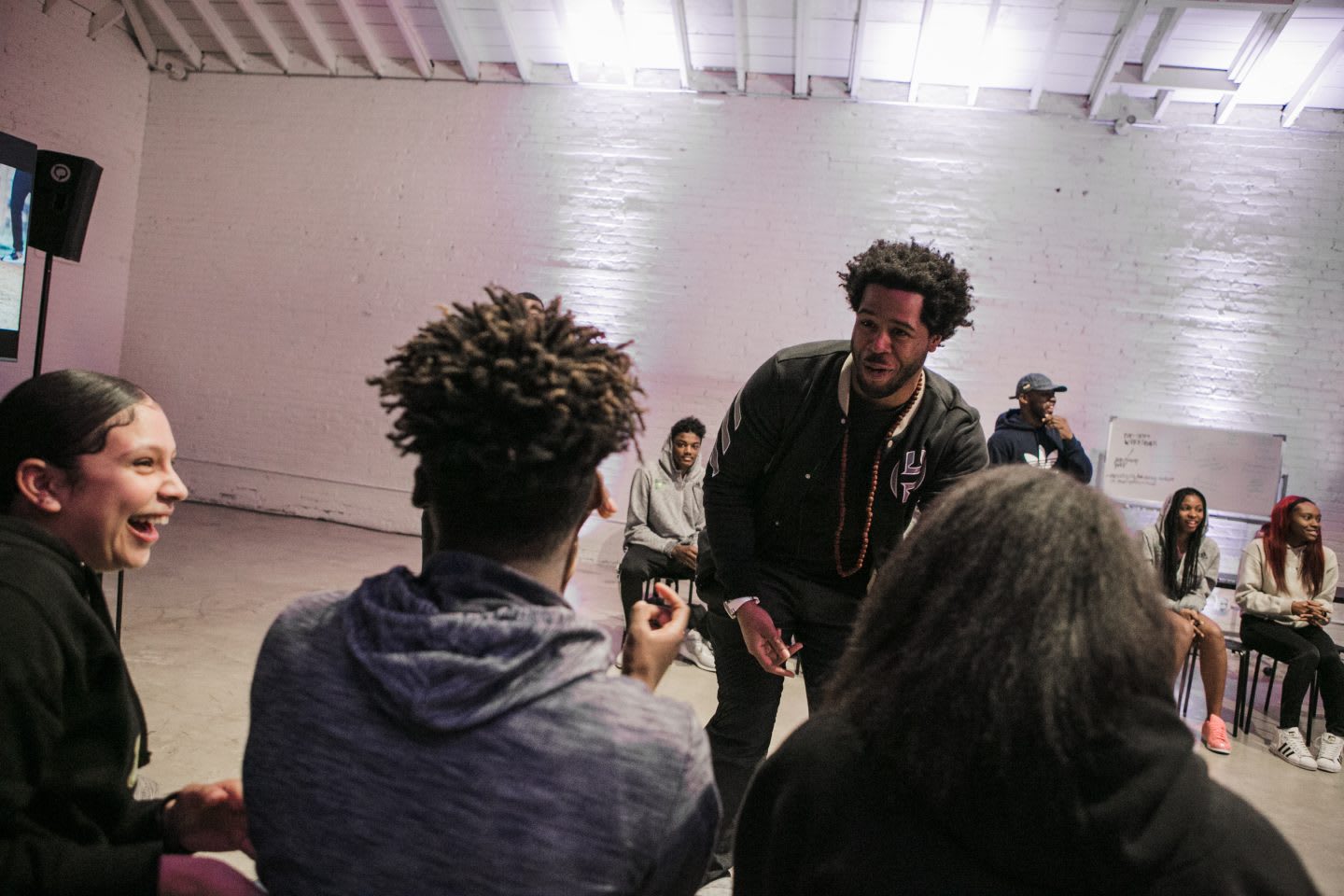 A mentor speaks with his team of kids in laughter. team, laughter, inspiration, role model
