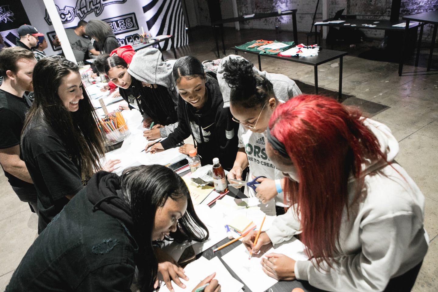 A group of girls draw and write down their ideas on paper as part of a workshop activity. collaboration, creativity, design, inspiration