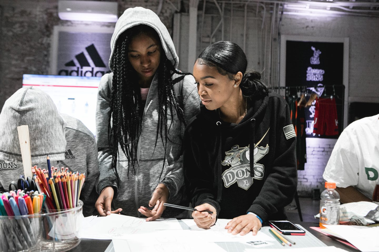 Two girls compare ideas and find inspiration from one another. collaboration, teamwork, inspiration, ideas, brainstorm