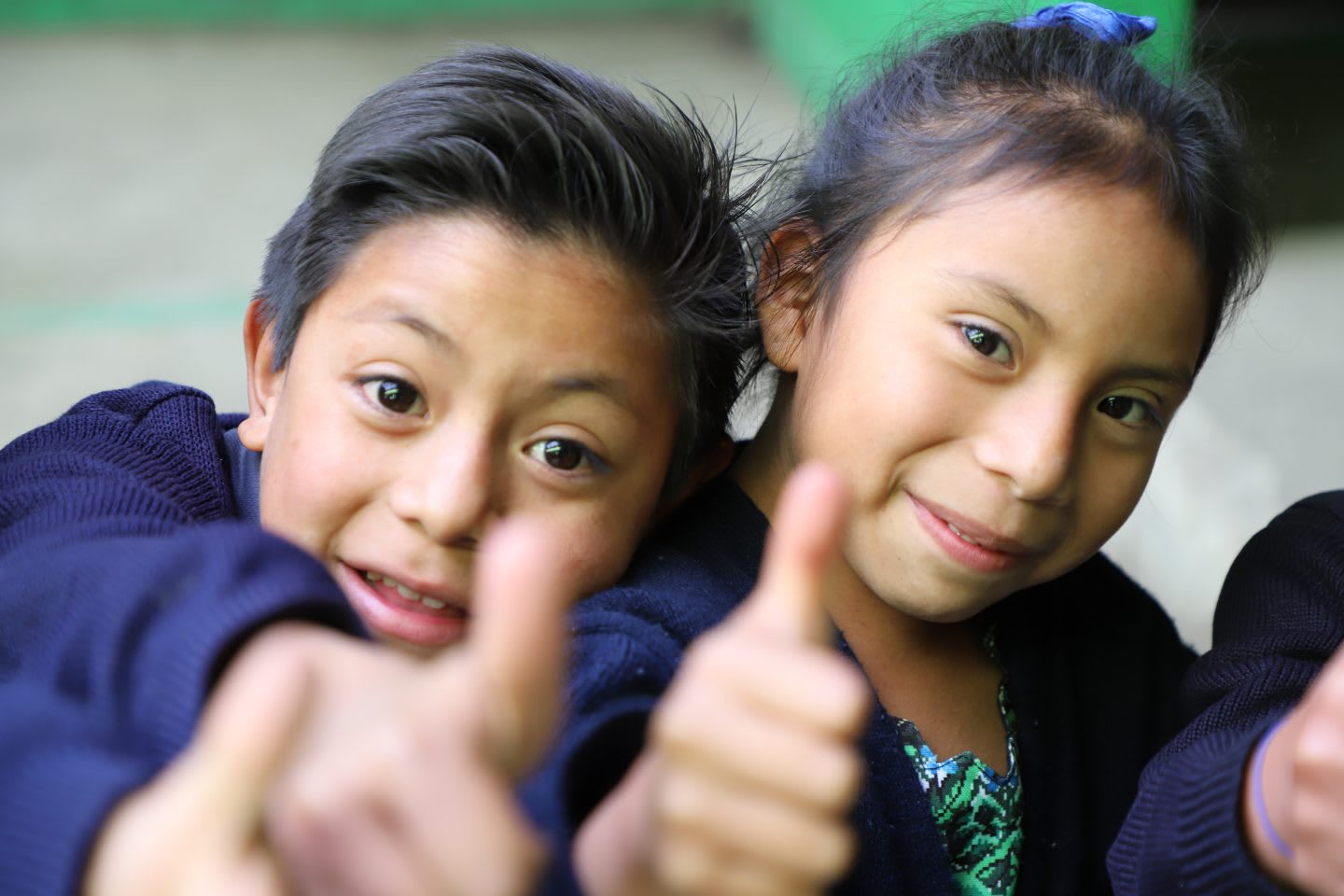Two children hold their thumbs up smiling. happy, children, accomplishment, proud