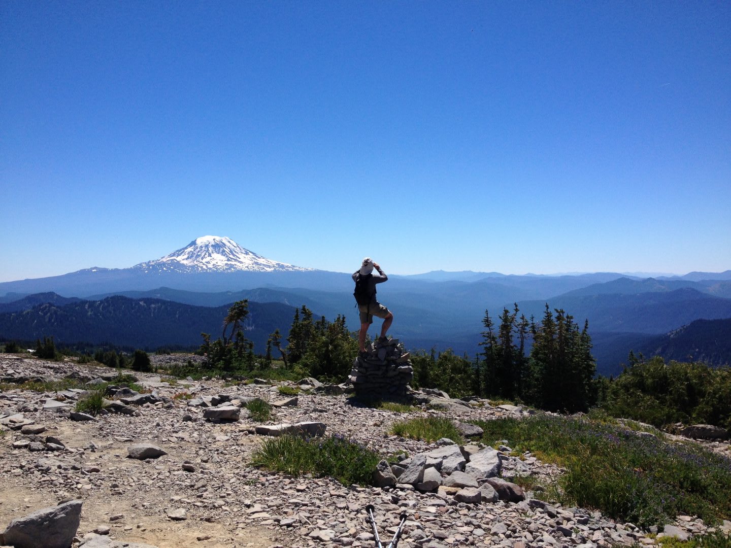 A man looks out into the distance on top of a mountain. reflection, achievement, outdoors, hiking