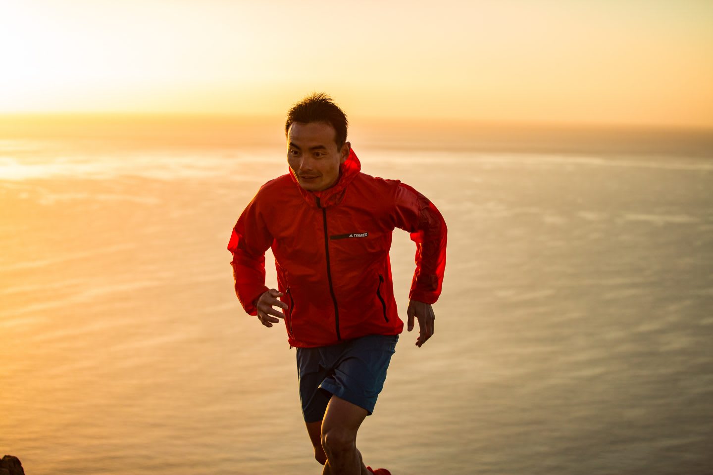 A runner looks focused on the trail ahead while running during the sunset. focus, running, runner, sunset, ocean
