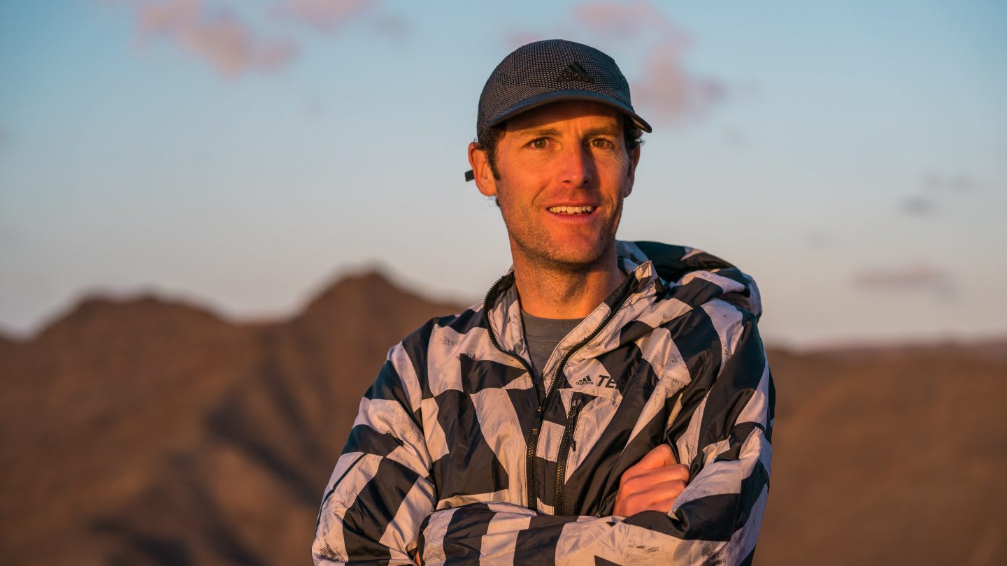 A adidas runner folds his arms while standing in the sunset. terrex, adidas, sunset, runner, dessert, mountains