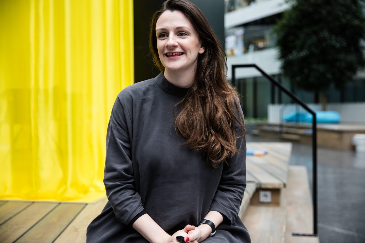 Woman sitting on a bench laughing at the adidas HQ. Lauren Currie, entrepreneur, public speaking, diversity, confidence, interview, GamePlan A