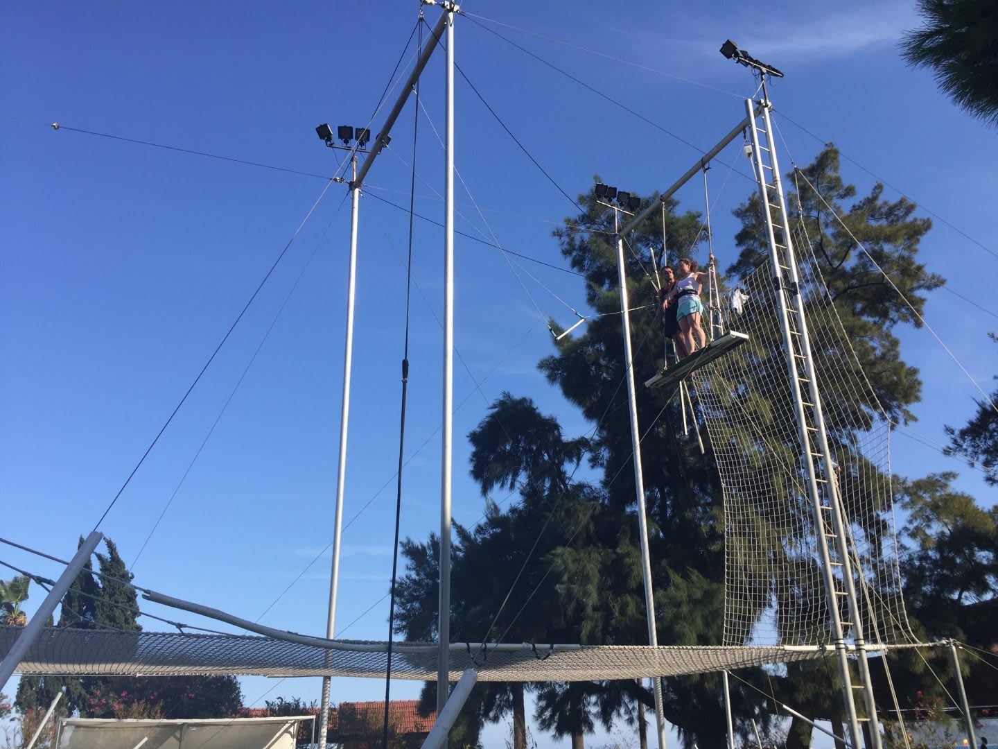 A trapeze net is waiting to catch the two trapeze artists who anticipate their jump. jump, faith, waiting, trapeze