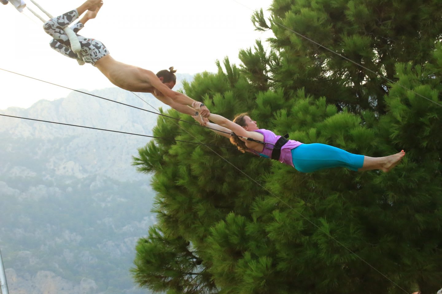two trapeze artists hold each other in the air. trapeze, jump, faith, trust