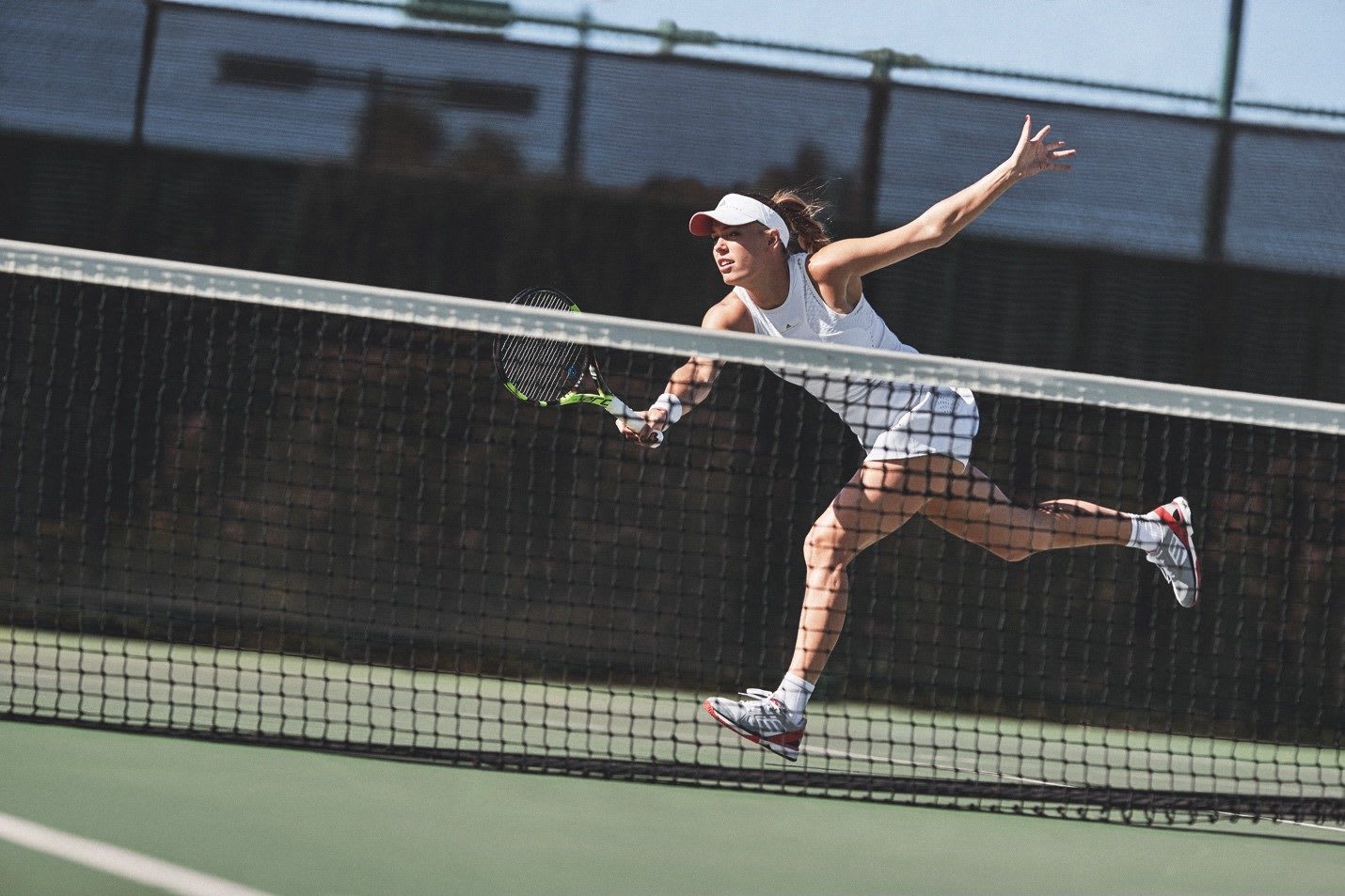 Woman lunging for tennis ball during match