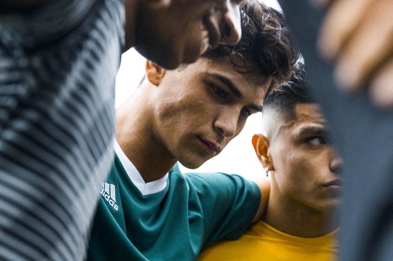 Three young men standing in a team huddle and are concentrated listening to their coach. career, success, adidas, GamePlan A, personal growth, attitude, motivation, Sports team-huddle-motivational speech