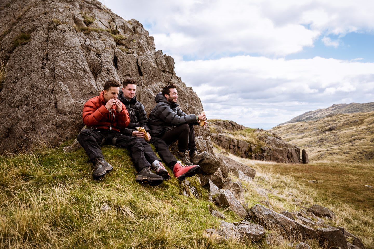 Three young male hiking friends eating sandwiches, The Lake District, Cumbria, UK, nutrition tips, healthy nutrition, fitness, outdoor, hiking, food, GamePlan A