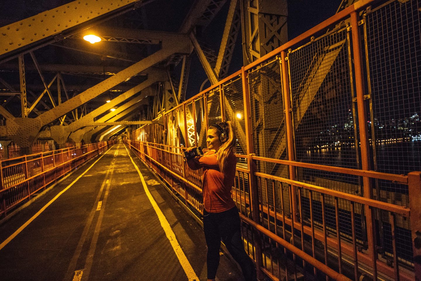 Woman stretching her muscles after a run at night on Brooklyn Bridge in New York, city run, sport, workout, after work exercise, inspiration, Brooklyn Bridge, New York, adidas, GamePlan A
