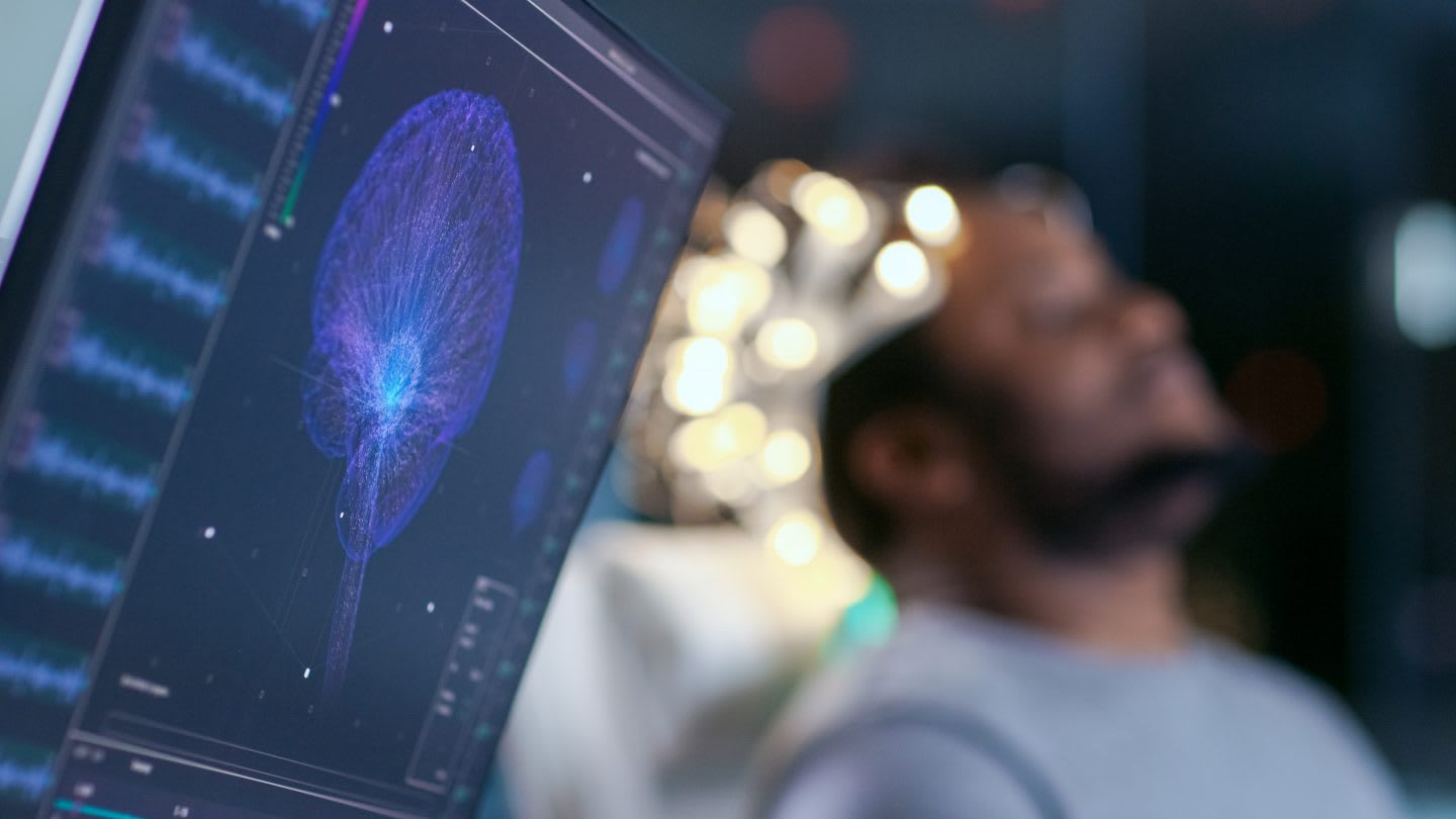 Monitors Show EEG Reading and Graphical Brain Model. In the Background Laboratory Man Wearing Brainwave Scanning Headset Sits in a Chair with Closed Eyes. In the Modern Brain Study Research Laboratory. Mental strength, brainwaves, career, sports, synchronized brains, performance, psychology, research, GamePlan A
