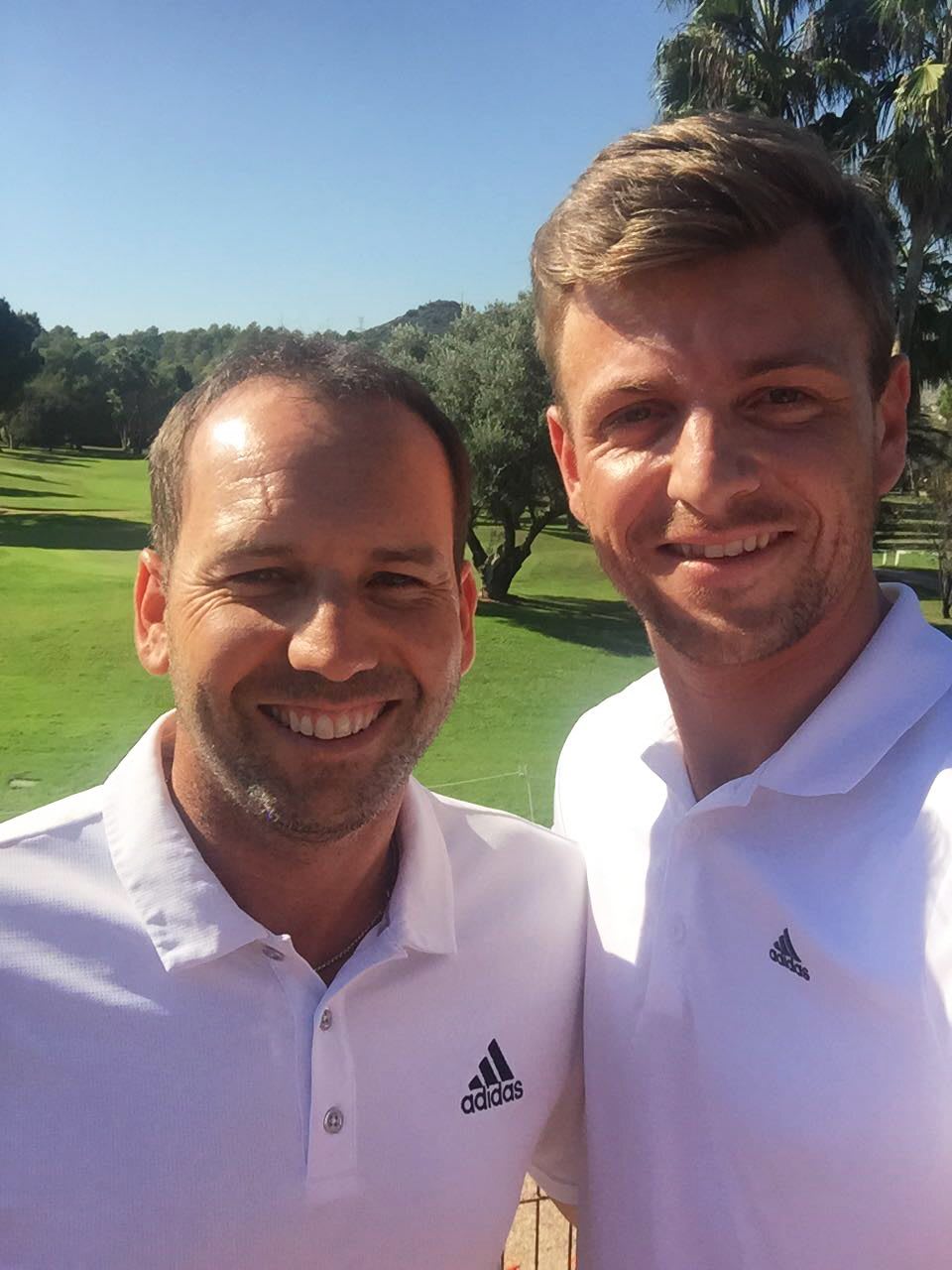 Sergio García and Ben Howlett smiling into the camera at a golf course, golf, golf course, pro athletes, sport, adidas, GamePlan A