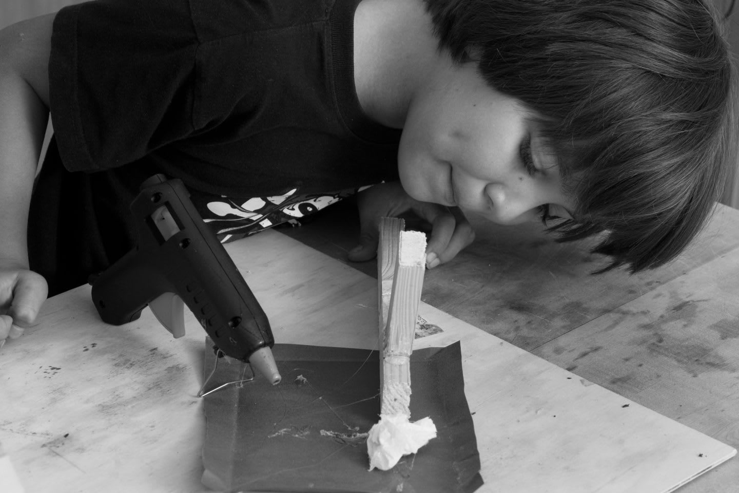 Little Boy using glue gun to stick together wood, creative work, craft, experimenting, creativity, GamePlan A
