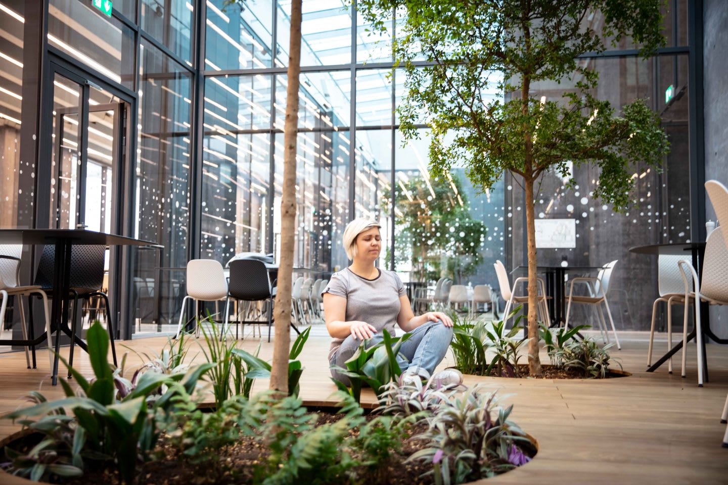 Woman sitting cross-legged in an open office space, work atmosphere, meditation, yoga, cross-legged, green space, adidas HQ, Herzogenaurach, GaamePlan A