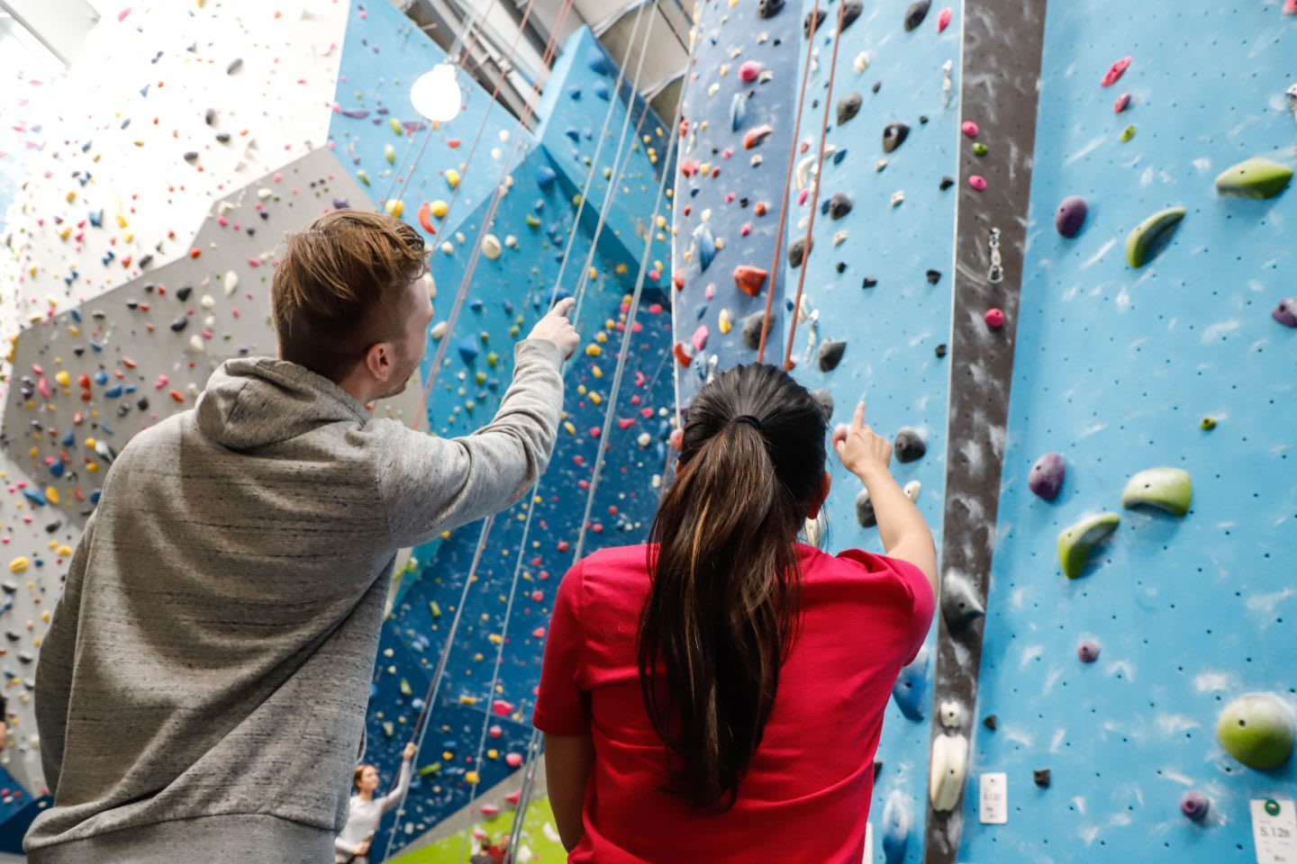 Two climbing partners look up to an indoor climbing wall and discussing the climbing route. challenge, overcoming fears, self-reflection, self-improvement, trust, leadership skills, GamePlan A