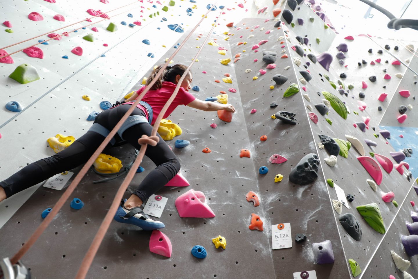 A woman climbing up an indoor climbing wall. challenge, overcoming fears, self-reflection, self-improvement, leadership skills, GamePlan A