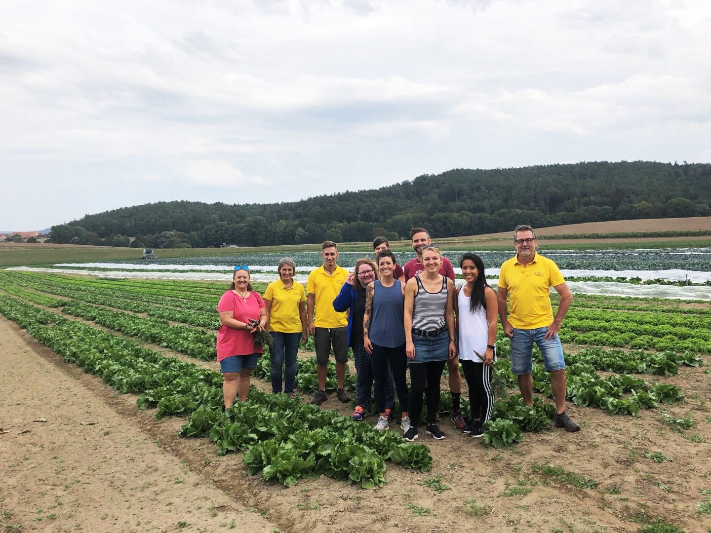 A group of people standing on a field and smiling into the camera. employees, sustainability, farming, career advice, purpose, GamePlan A