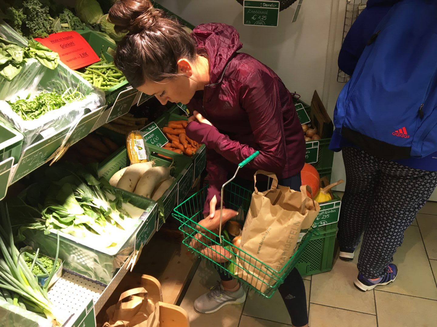 A woman is putting different vegetables in her shopping bag in a supermarket. employees, sustainability, learning, purpose, career advice, GamePlan A