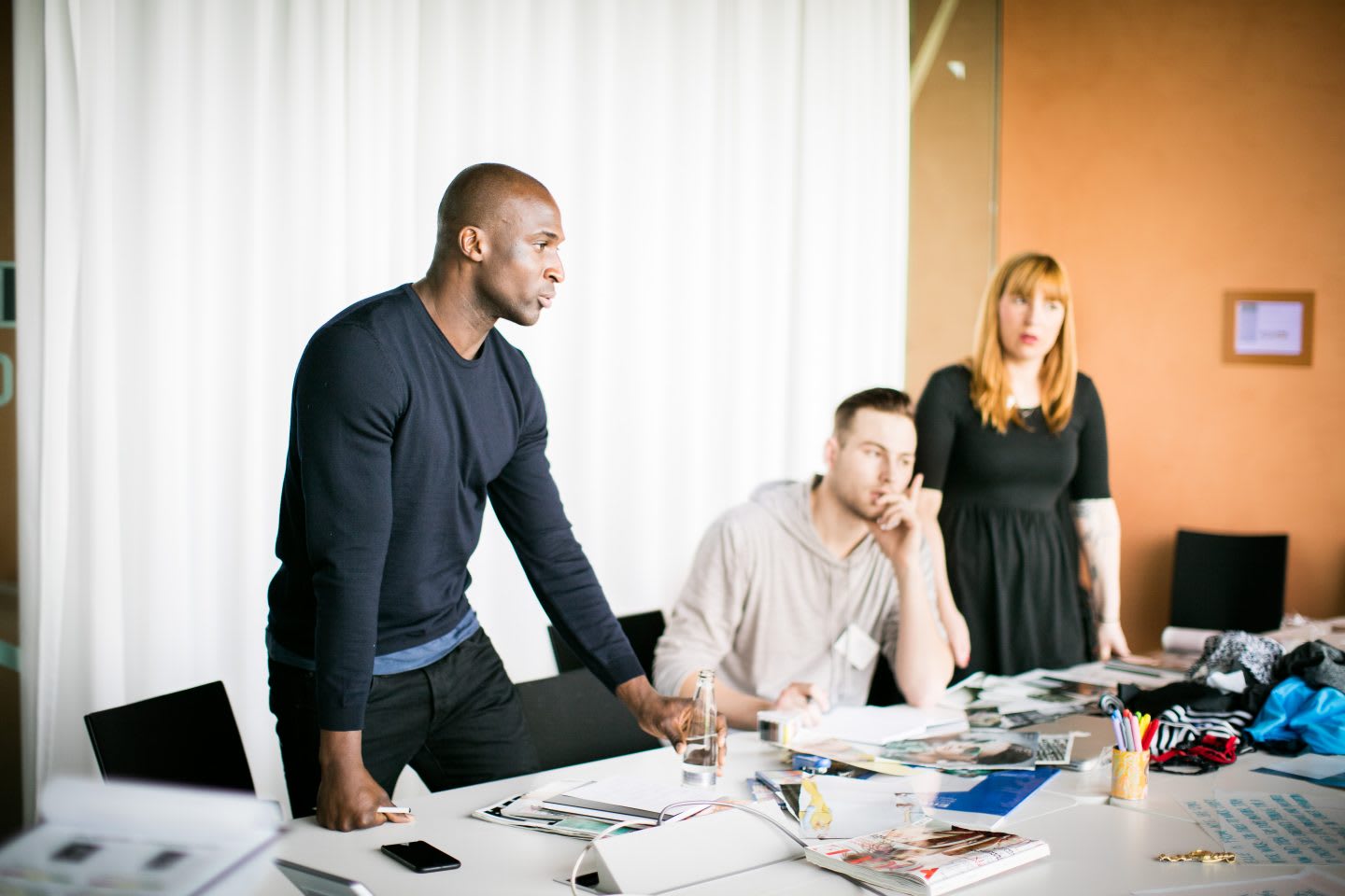 A team at a large office table holding a meeting. coaching, leadership, team, role model, GamePlan A