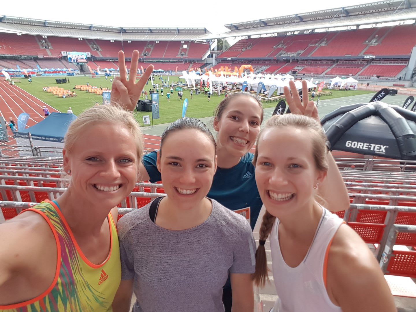 A group of women at a running competition in a stadium. Group running, coaching, performance, company run, track, GamePlan A