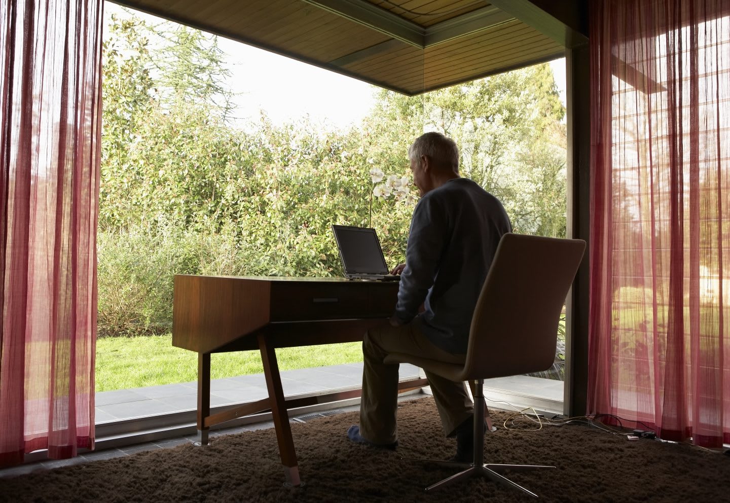 Man working at desk in front of window. The ideal space to let his mind wander.