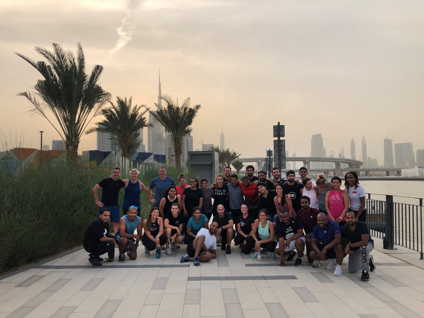 A group of runners standing together for a group picture in front of a city skyline. winning culture, motivation, success, personal growth