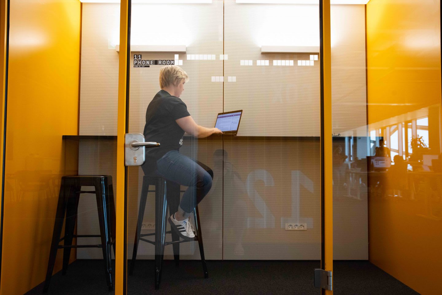 An adidas employee sitting in one of the focus boxes with her laptop. | Taking a break at work