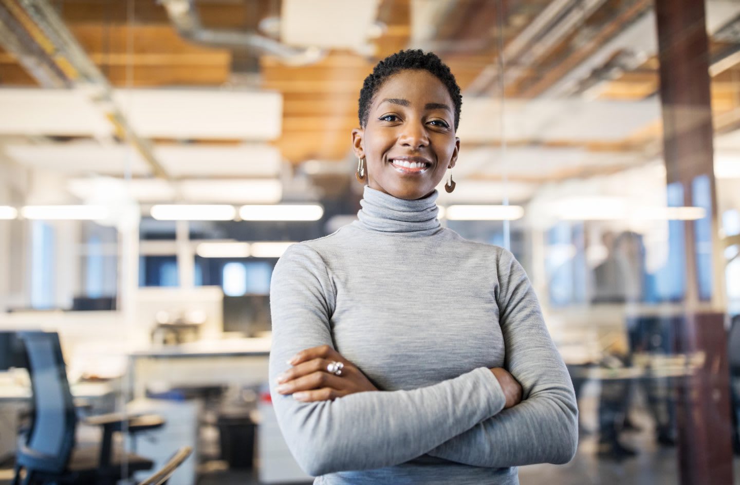 Portrait of businesswoman standing in office with her arms crossed. | Sorry