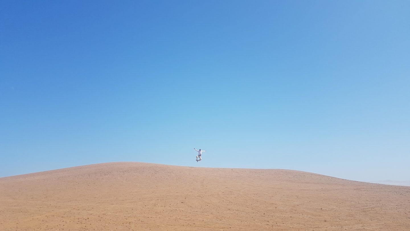 A man jumping in the desert. disconnect on vacation, holiday, work, detox
