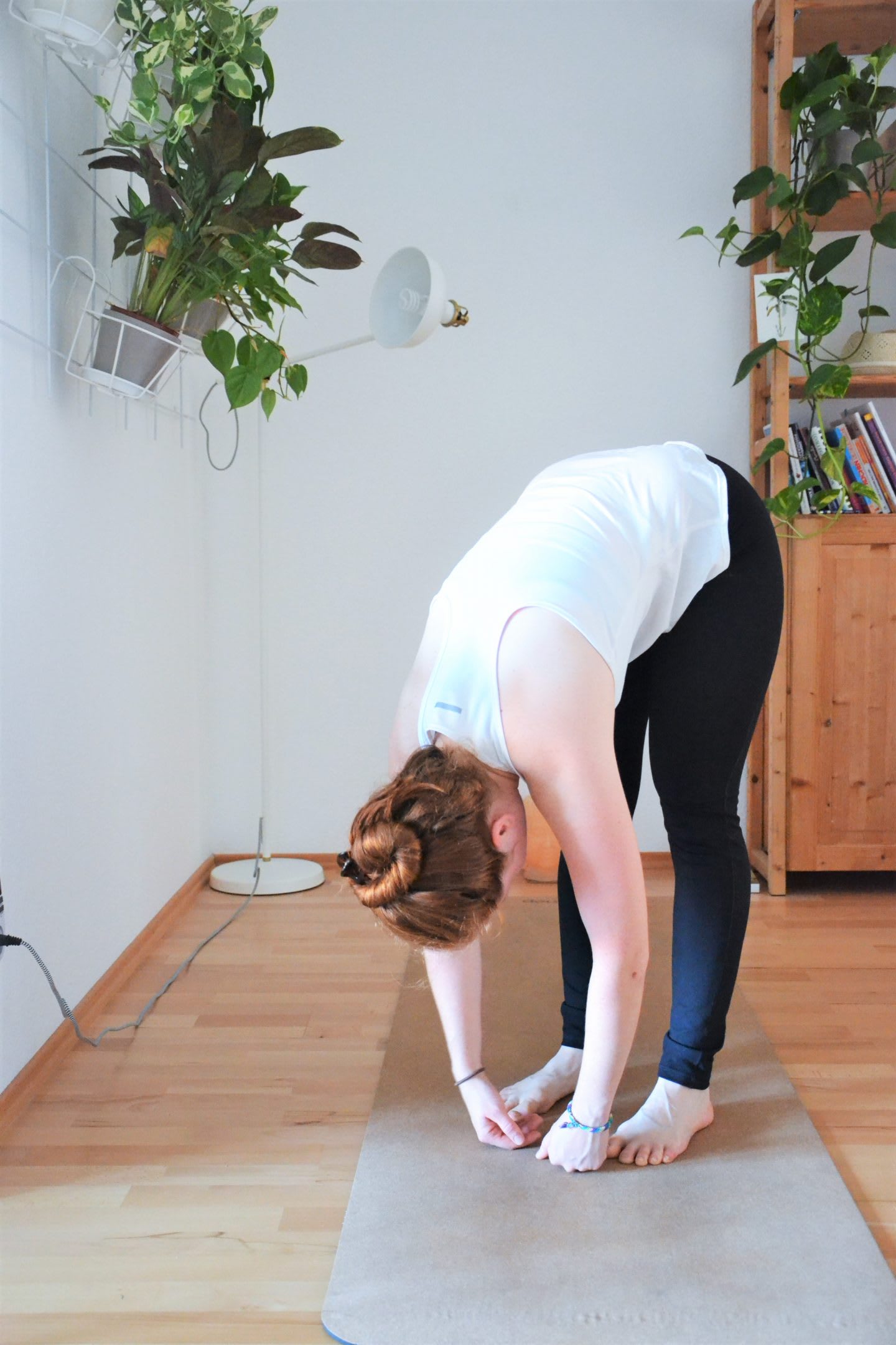 Woman practicing standing forward bend. Focus, yoga, GameplanA