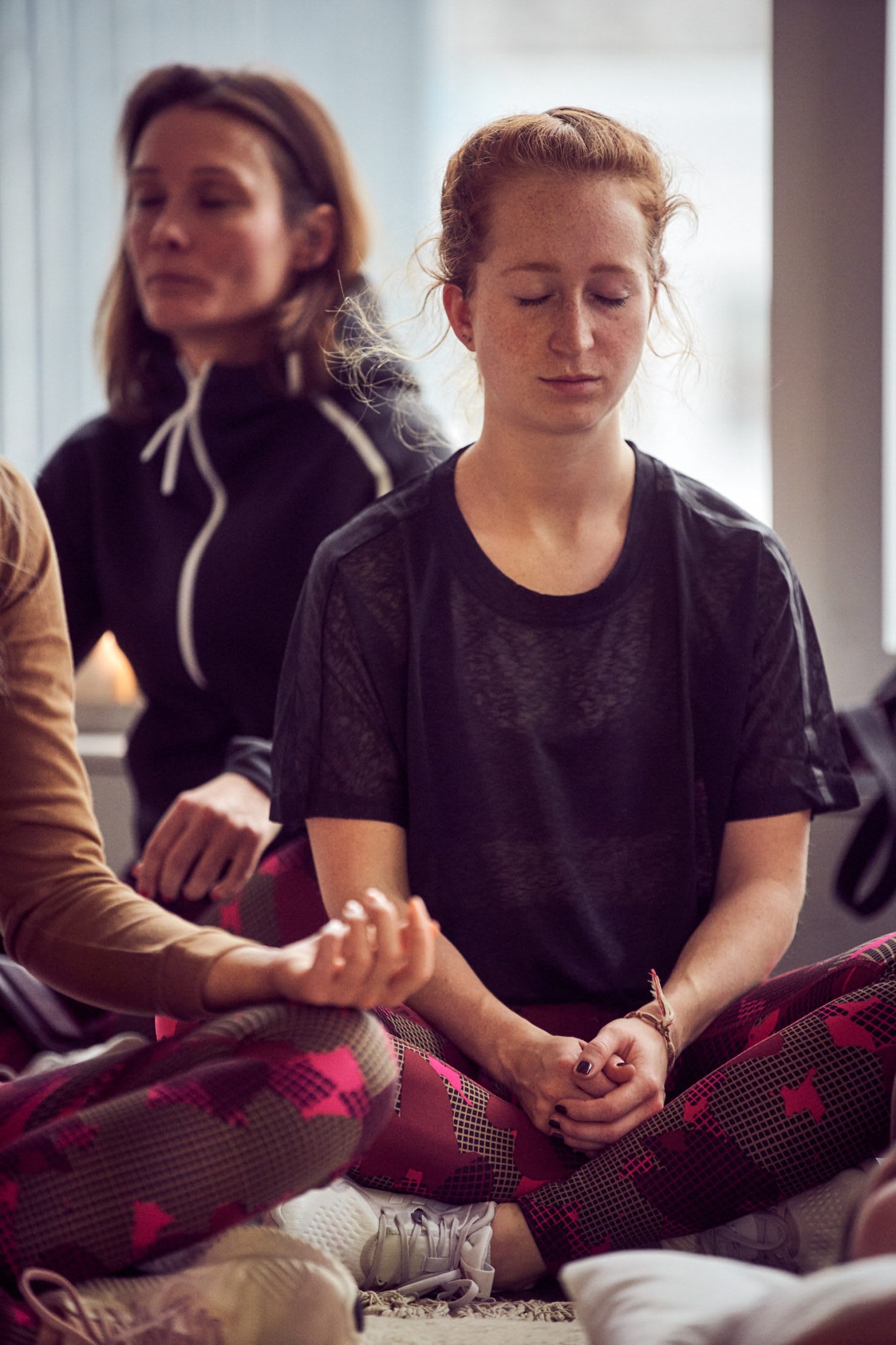 Women practicing meditation on the floor.