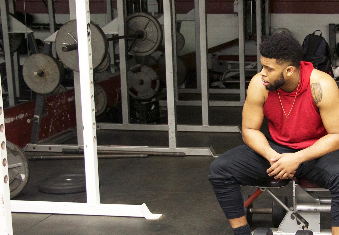 A man is sitting on a bench in the gym taking a break during his workout. student-athlete, studying, sports, social life, balance, mindset