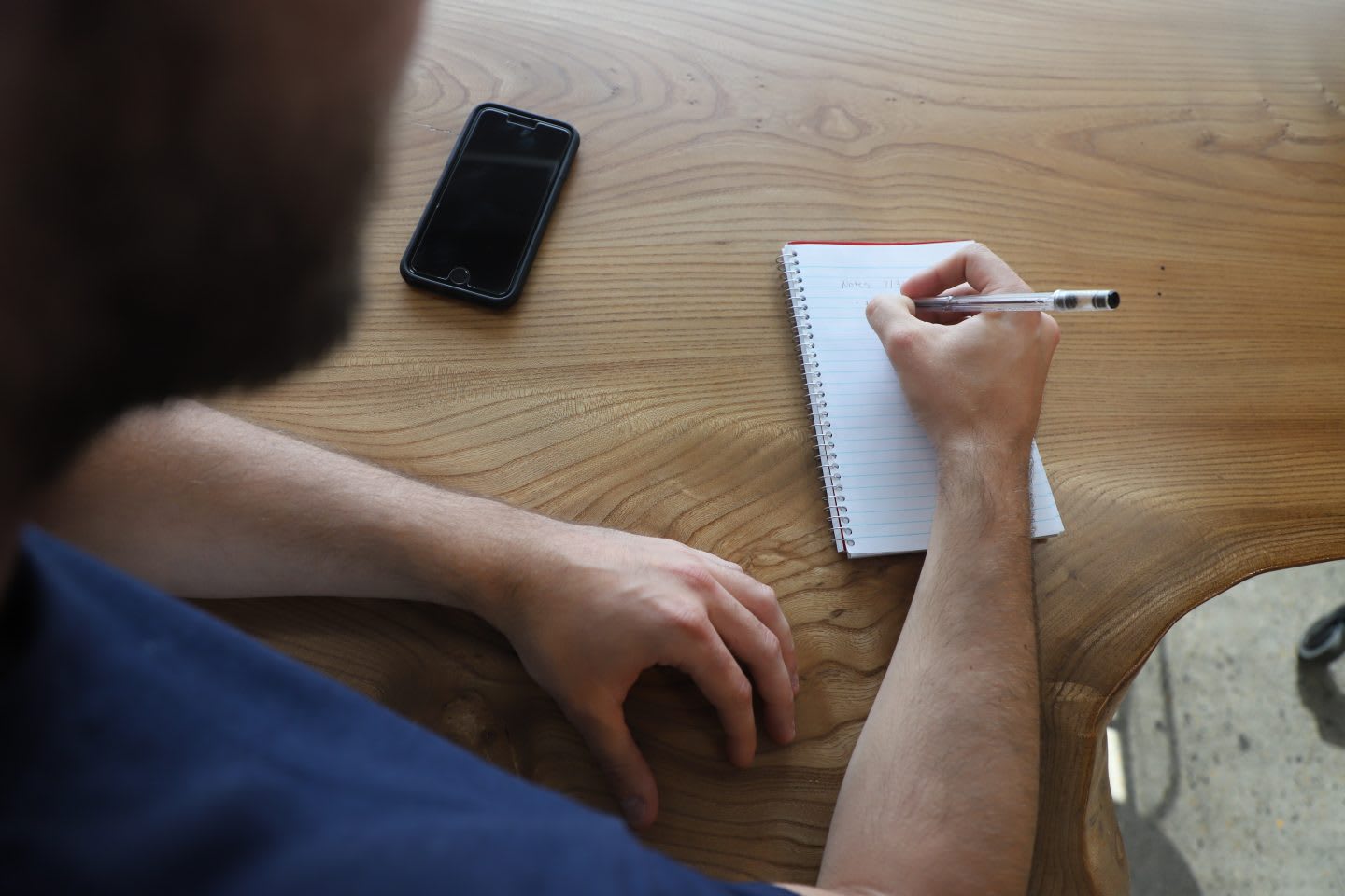 A man is taking notes on a small notepad. team, success, work, GamePlan A