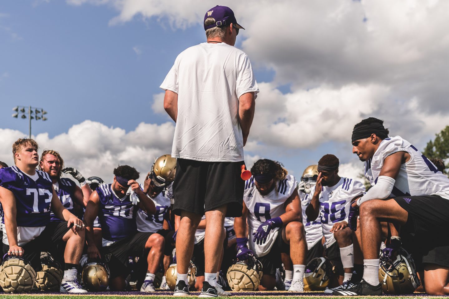 coach talking to his team of american football players
