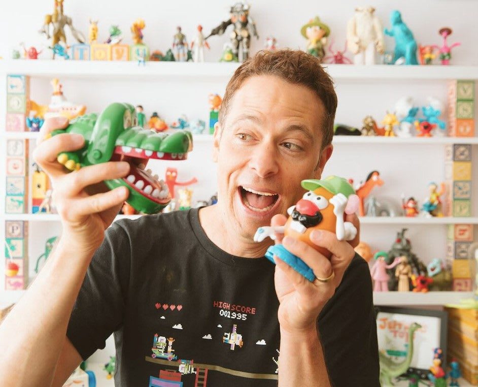 Matthew Luhn plays with figurines from the toy story film franchise.