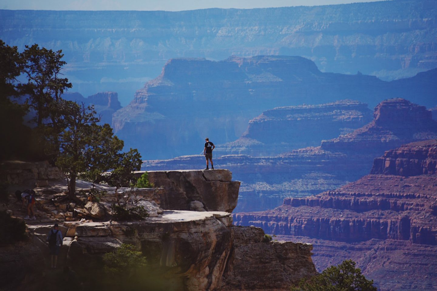 Eric Tobin stands on top of a rock looking down into the Grand Canyon.